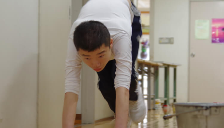 園生が廊下で走り拭きをしています