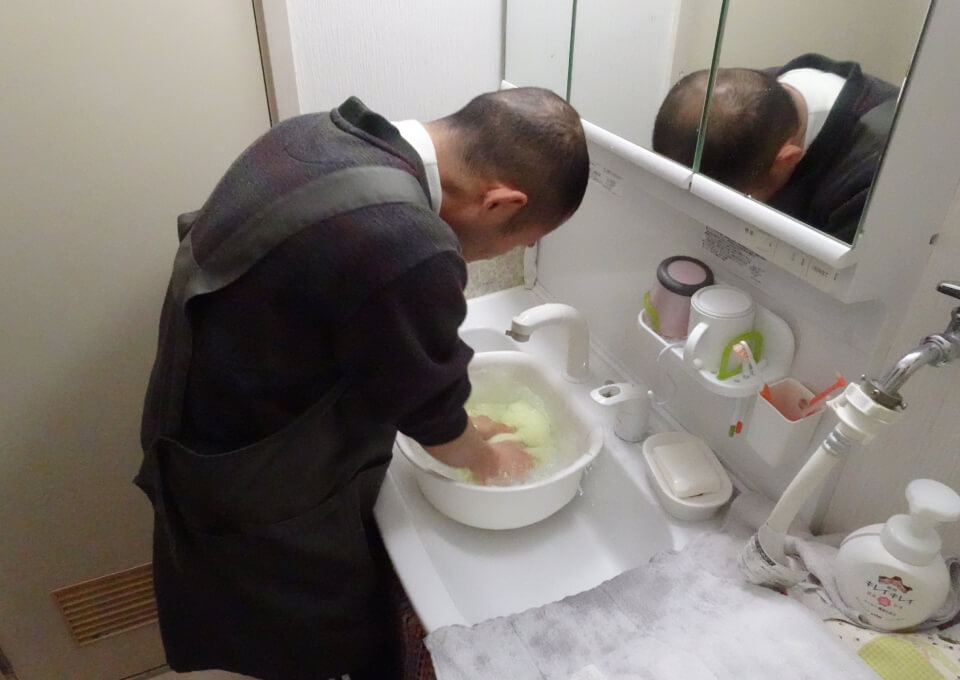 カズさんが洗面所で洗濯をしています