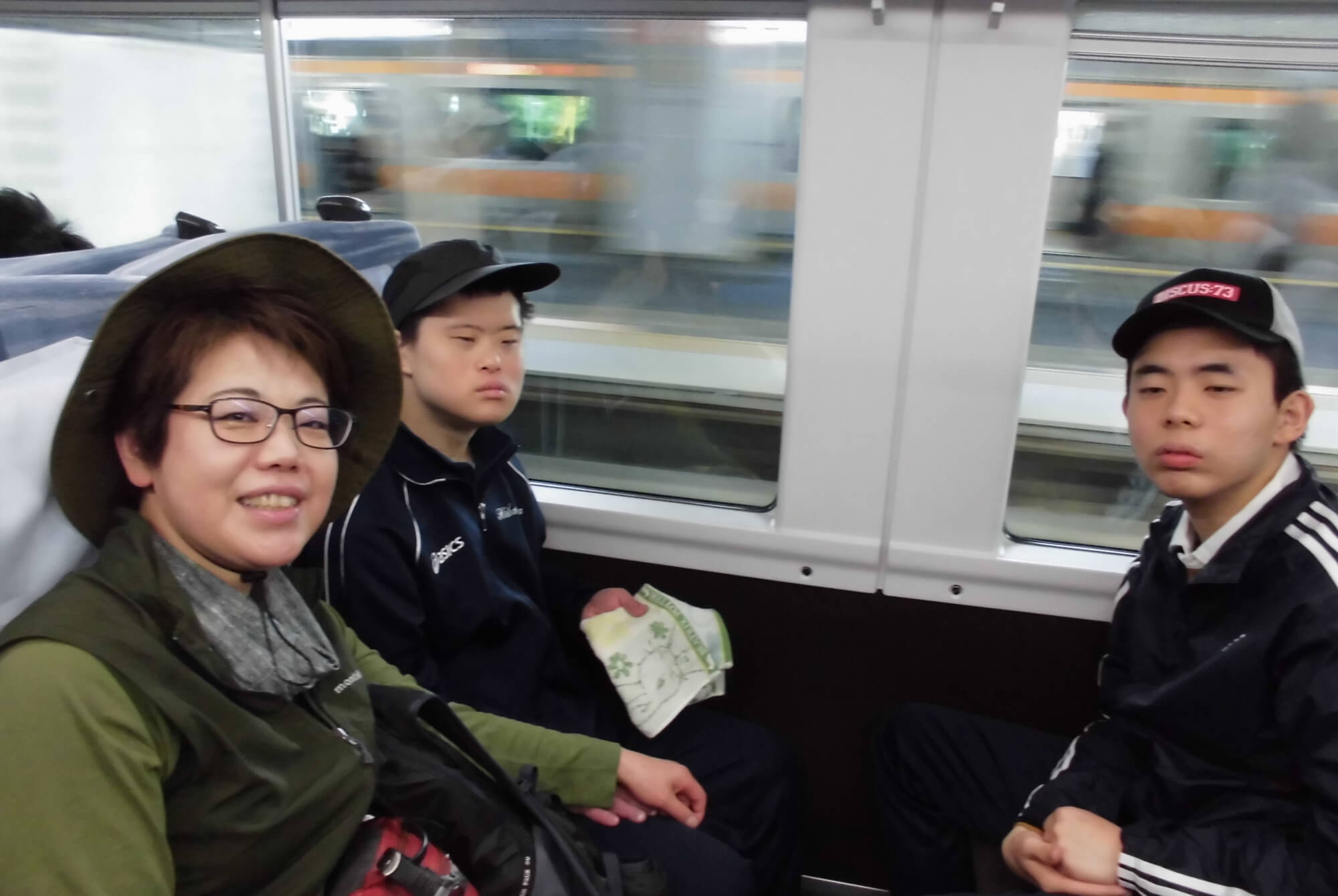 高橋施設長が園生達と一緒に電車に乗っています