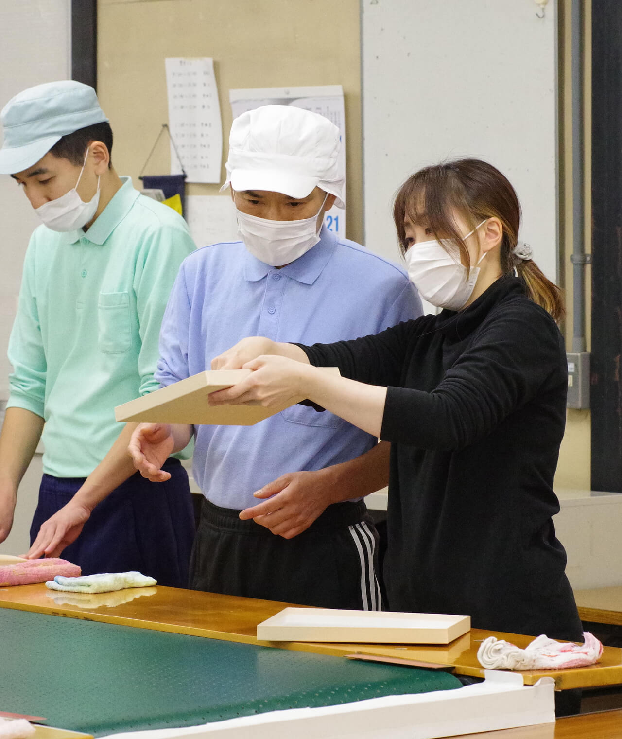 れいさんが園生が作った紙器の出来具合を確認しています