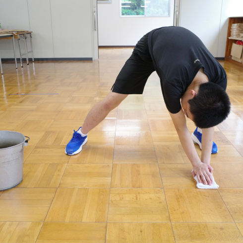 バケツをずらして床を拭ています