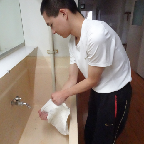床を拭いた雑巾を濯いています